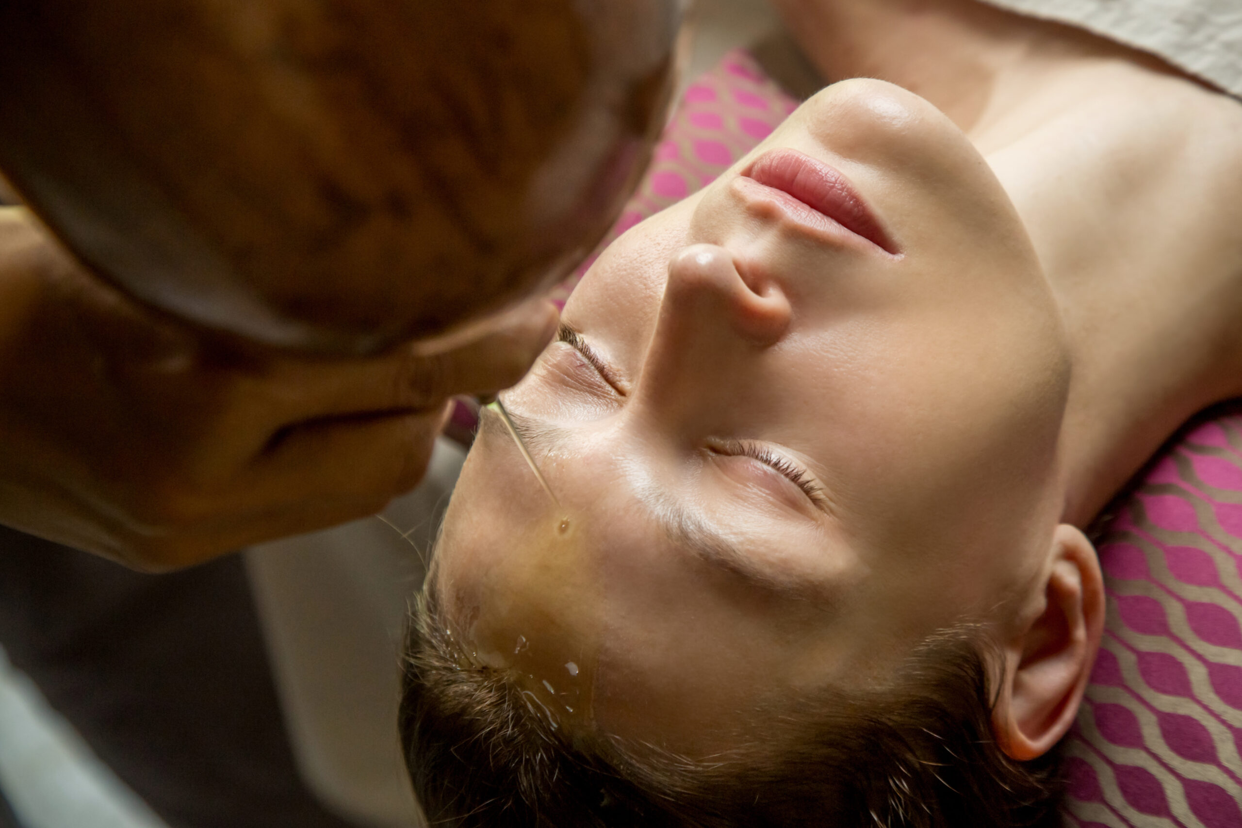 Shirodhara, an Ayurvedic healing technique. Oil dripping on the